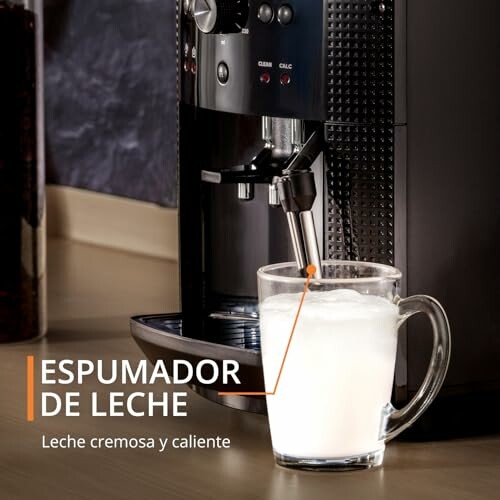 Máquina de café con espumador de leche y taza llena de leche espumosa.